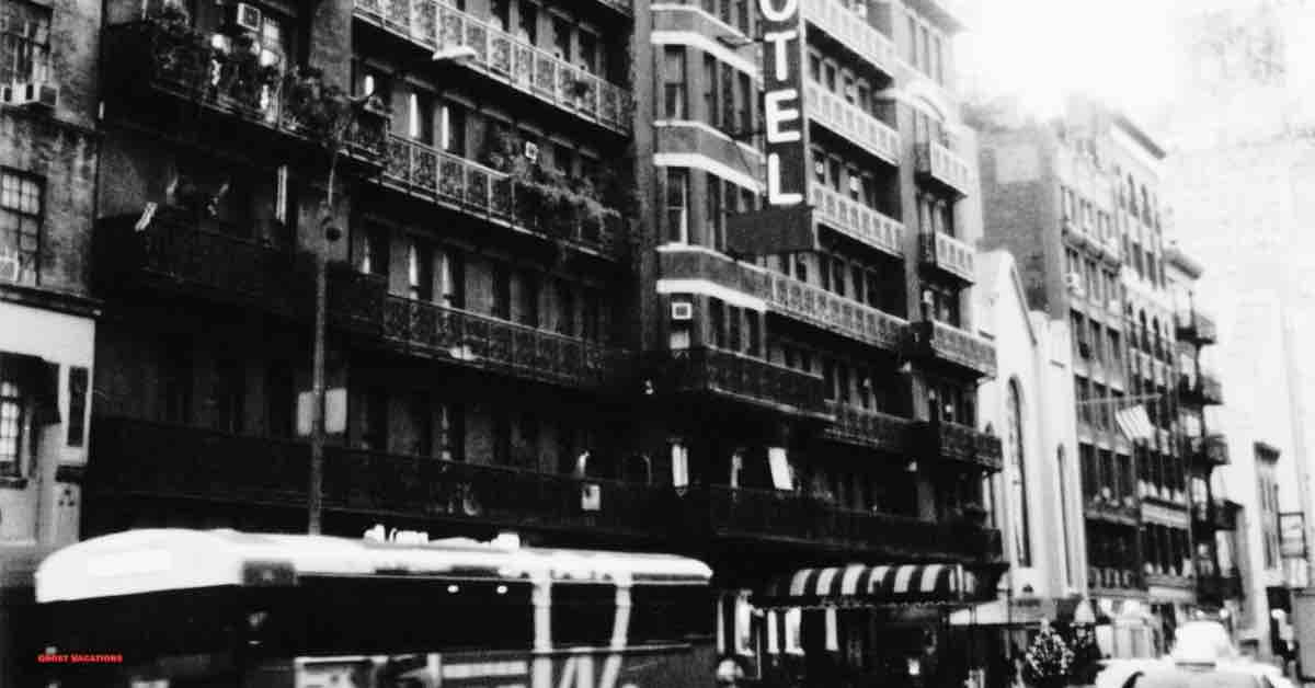 Black and white photo of the Chelsea Hotel facade at night, invoking the eerie presence of the rumored Chelsea Hotel ghosts.