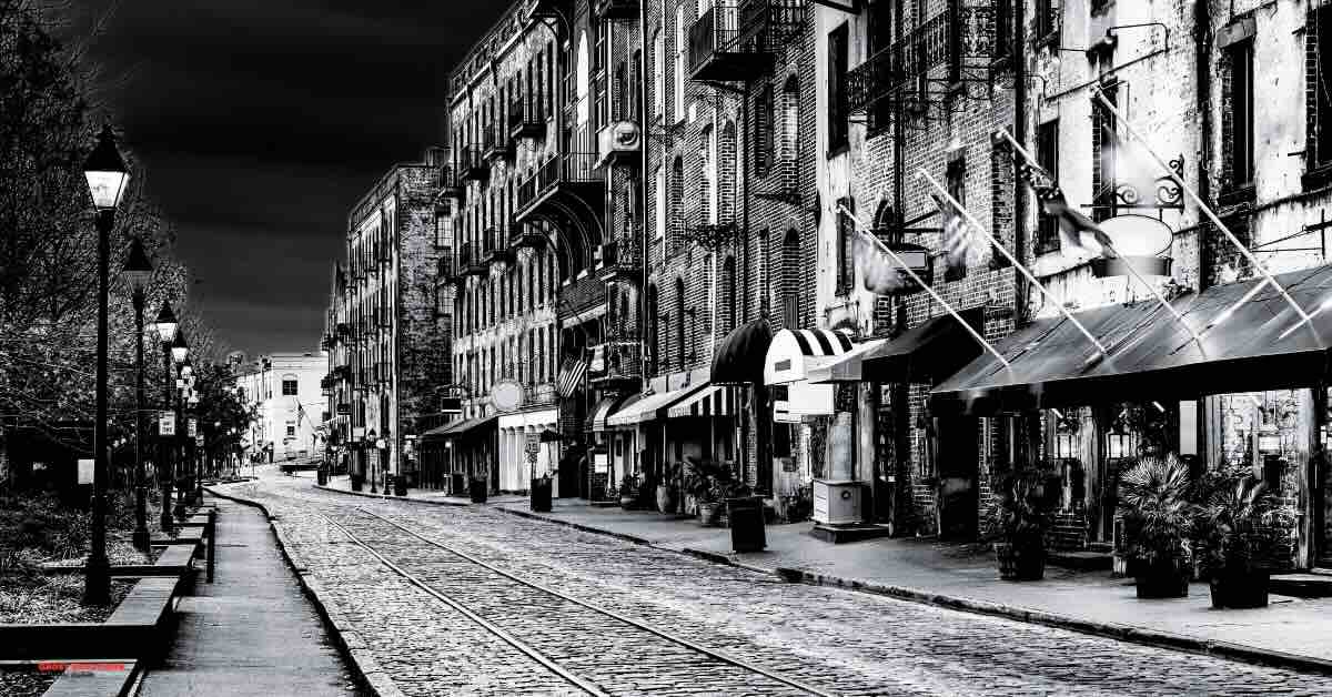 "Scenic view of River Street in Savannah, GA, with historic buildings and bustling nightlife. Perfect backdrop for ghost pub tours Savannah GA."