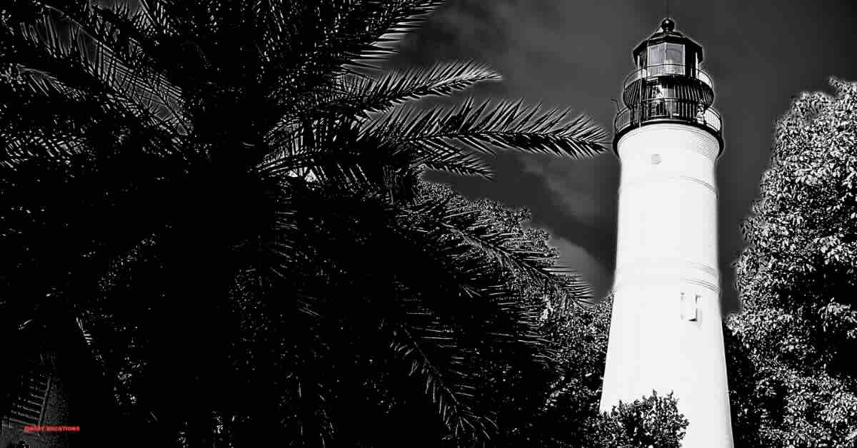 Key West Lighthouse surrounded by lush greenery, often featured in ghost tours in Key West FL, highlighting its haunted history and paranormal tales.