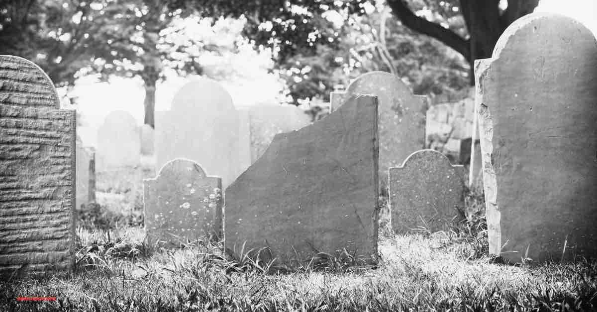 Hauntingly beautiful image of Burying Point Cemetery, a key location on Salem walking ghost tours, showcasing historic gravestones under a moonlit sky.