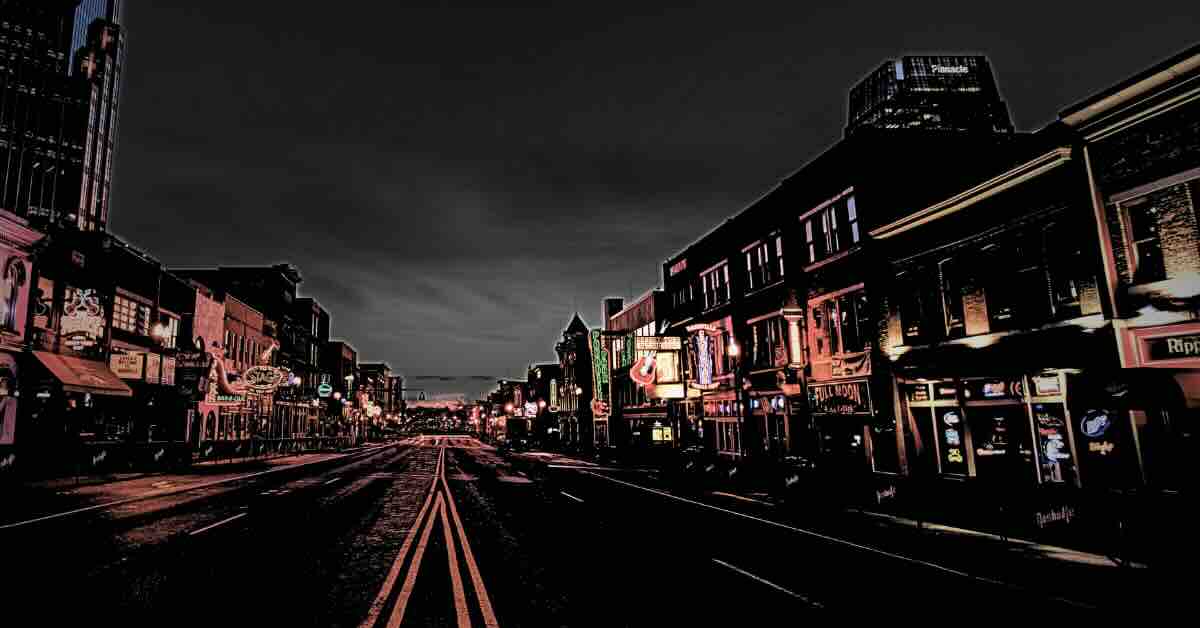 A view of Broadway in downtown Nashville, Tennessee, bustling with nightlife and historic buildings, perfect for exploring ghost tours in Nashville TN.