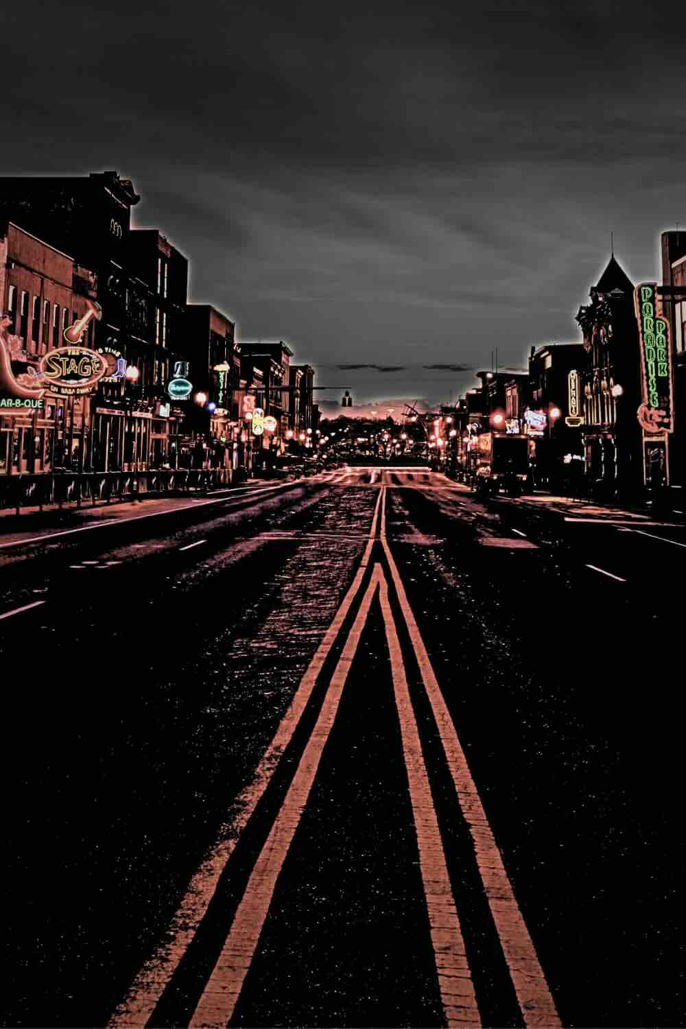 Bustling Broadway in downtown Nashville, Tennessee, illuminated at night, offering a vibrant backdrop for exciting ghost tours in Nashville TN.