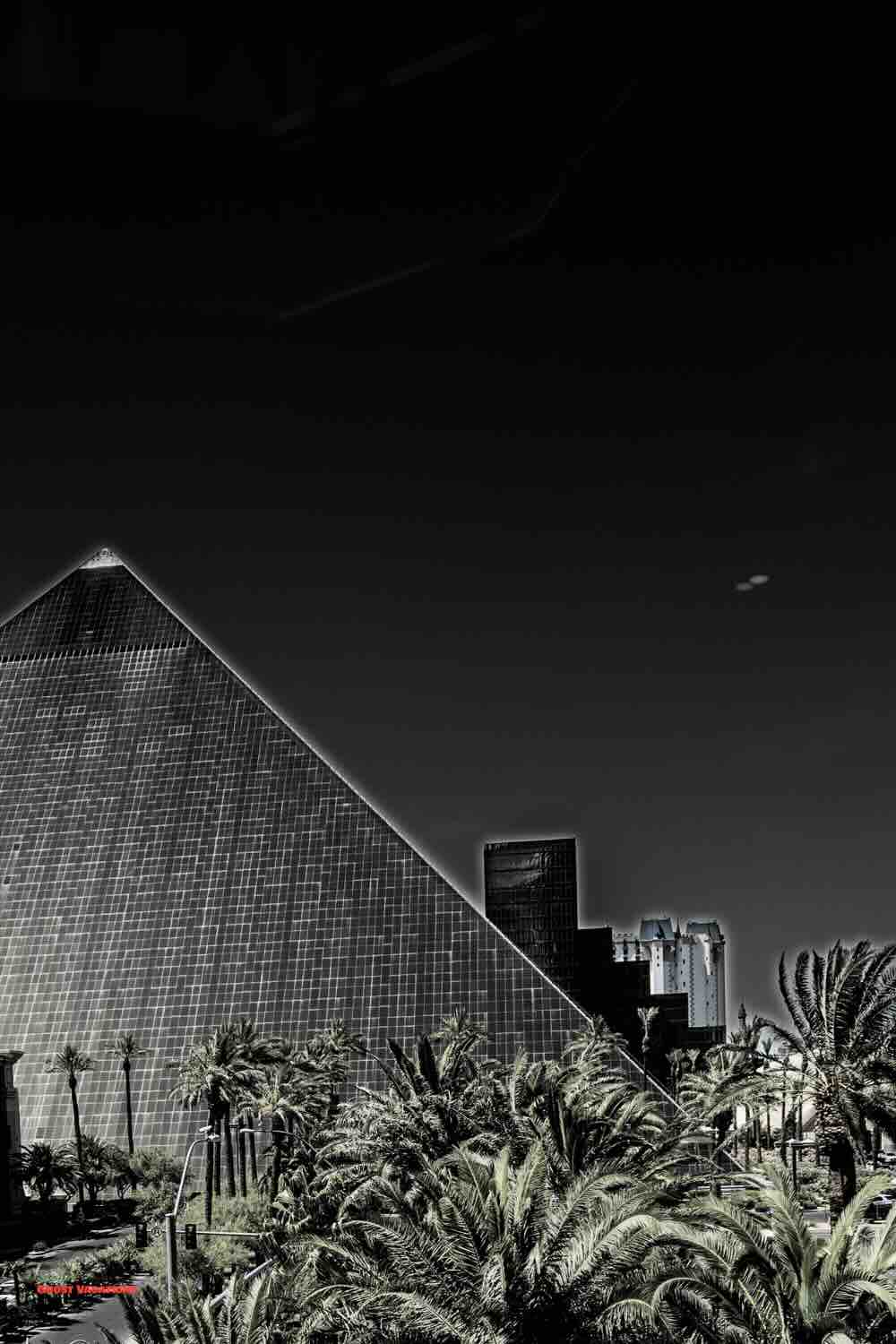 "Luxor Hotel in Las Vegas at night, showcasing the iconic pyramid structure with a bright beam of light shooting into the sky, one of the most haunted hotels in Las Vegas."