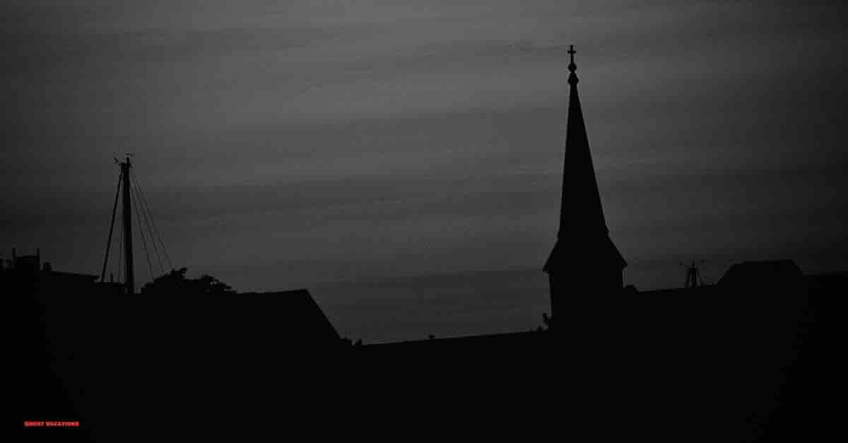 A picturesque view of Salem's skyline at dusk, with historic buildings silhouetted against the sky, hinting at the eerie tales of haunted hotels in Salem MA.