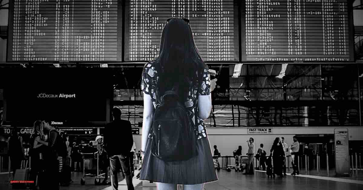 A woman in an airport terminal looking at promotion codes for flights.