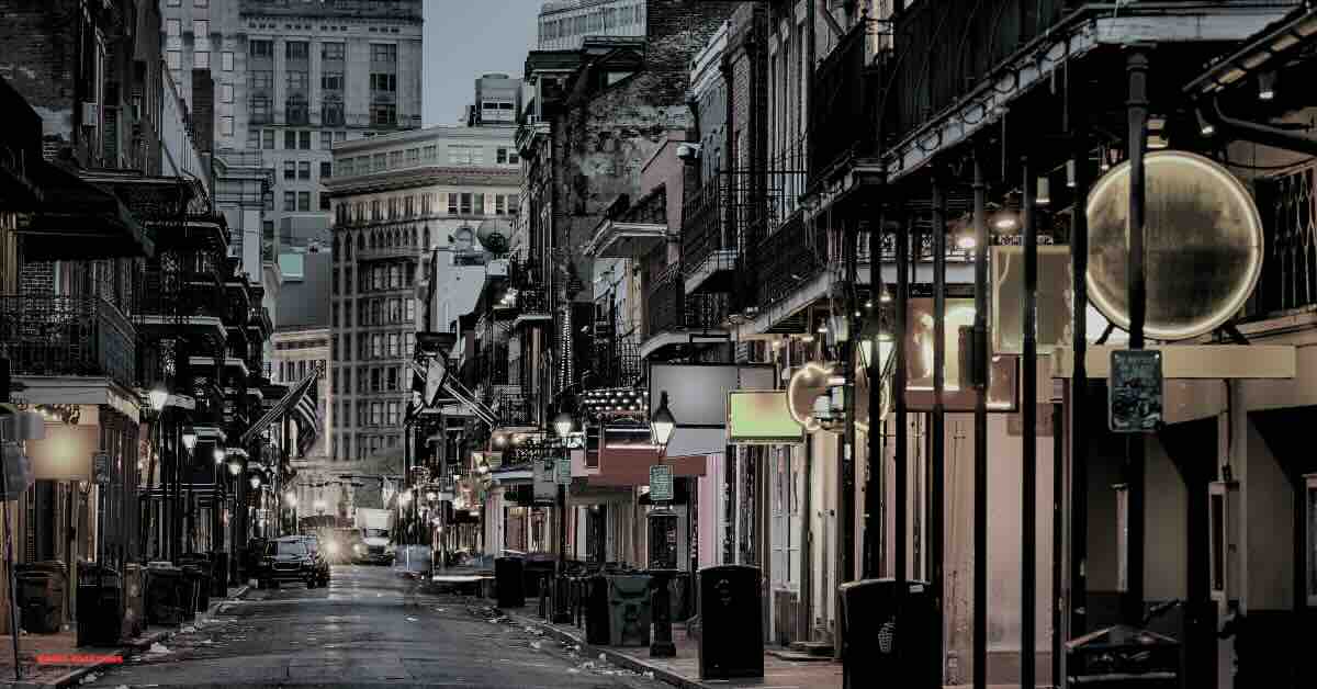 Bourbon Street scene at night with vibrant lights and historic buildings, part of the self guided ghost tour New Orleans.